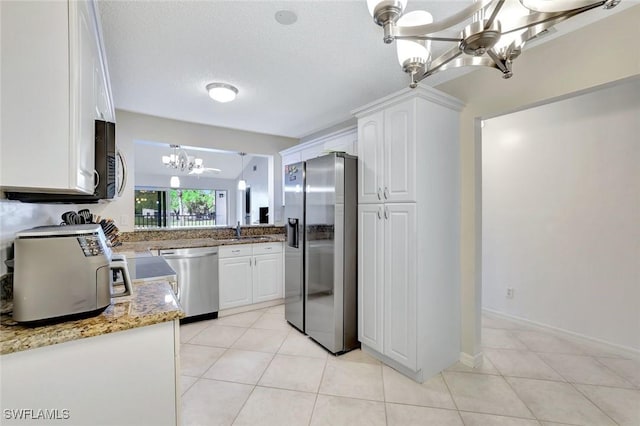 kitchen with a sink, appliances with stainless steel finishes, a chandelier, and white cabinets