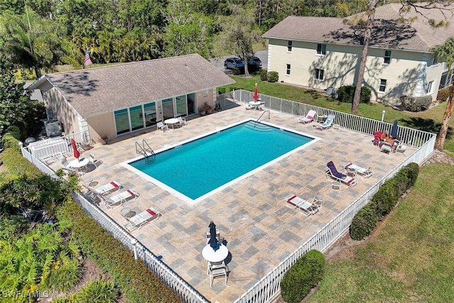 pool featuring a patio, a lawn, and fence