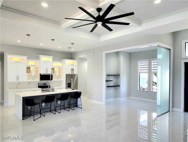 kitchen with stainless steel appliances, a large island, white cabinets, and a kitchen breakfast bar