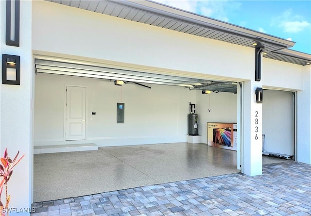 garage with decorative driveway, water heater, and electric panel