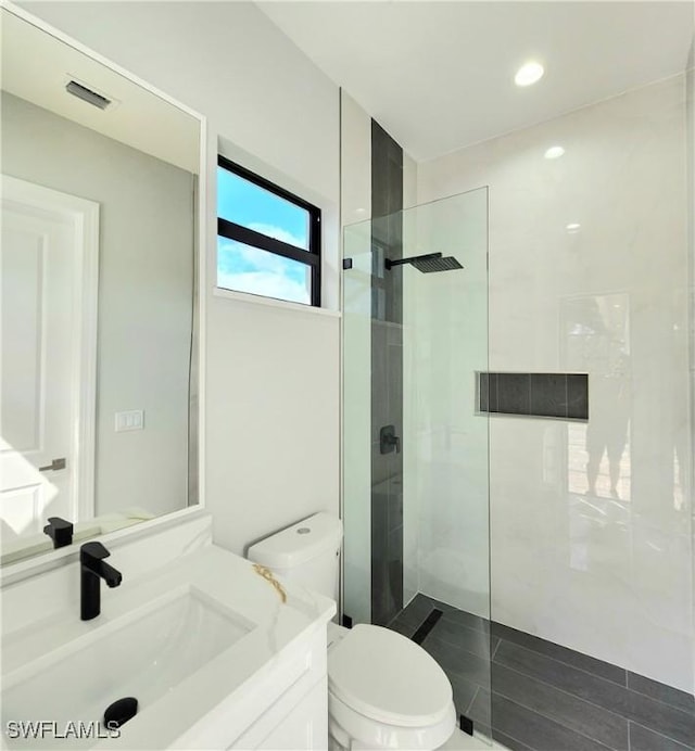 full bath featuring visible vents, vanity, walk in shower, and toilet