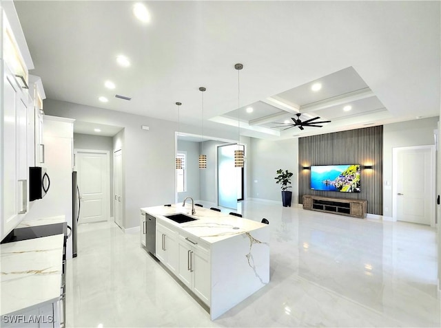 kitchen featuring white cabinets, a ceiling fan, marble finish floor, a large island with sink, and a sink