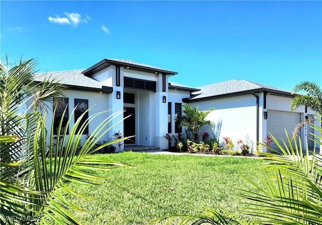 view of front of house featuring a garage, a front lawn, a shingled roof, and stucco siding