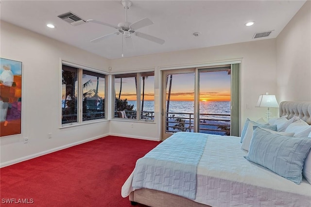 carpeted bedroom featuring visible vents, a water view, baseboards, and access to exterior