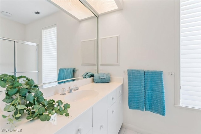 bathroom with visible vents, a shower stall, and vanity