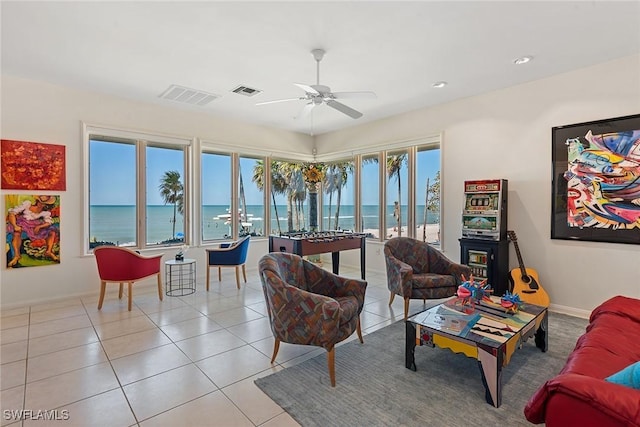 living room featuring tile patterned floors, visible vents, baseboards, and a ceiling fan