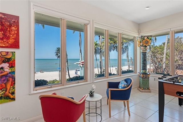 interior space featuring light tile patterned floors, baseboards, and a water view