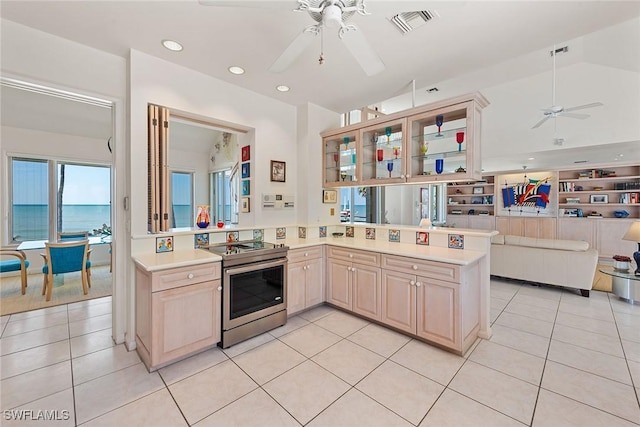 kitchen featuring light tile patterned floors, stainless steel electric stove, light countertops, and visible vents