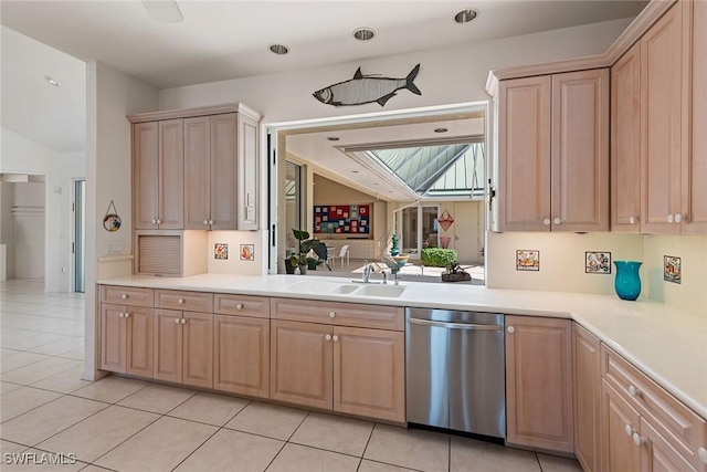 kitchen featuring light brown cabinets, a sink, stainless steel dishwasher, light countertops, and light tile patterned floors