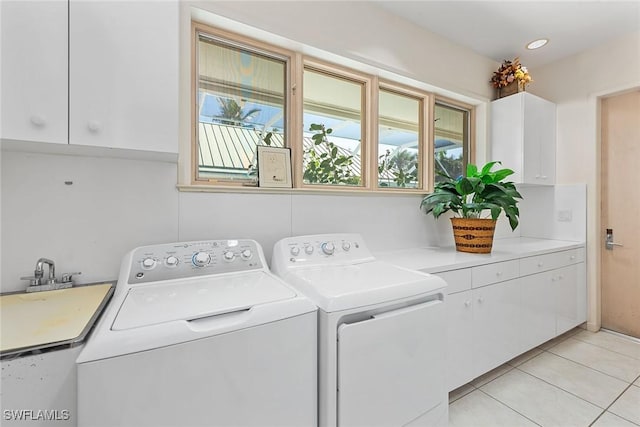 clothes washing area featuring a sink, light tile patterned floors, cabinet space, and washing machine and clothes dryer