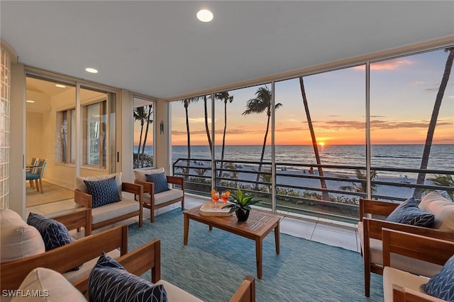 sunroom / solarium with a water view and a healthy amount of sunlight