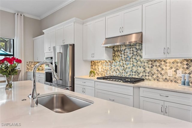 kitchen with ornamental molding, stainless steel appliances, under cabinet range hood, white cabinetry, and a sink