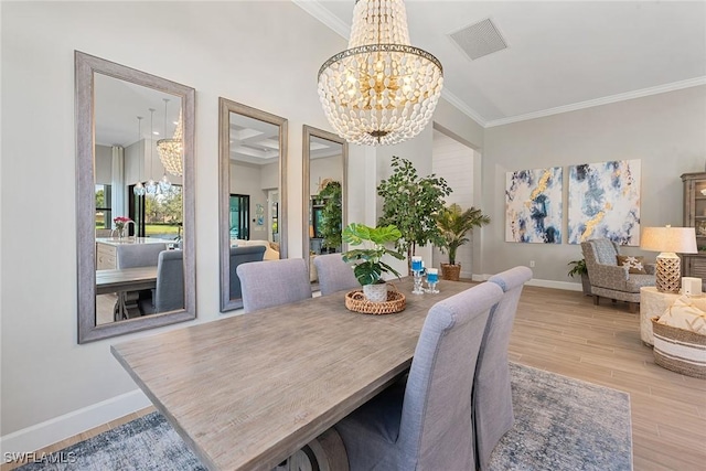 dining area featuring visible vents, ornamental molding, wood finished floors, a chandelier, and baseboards