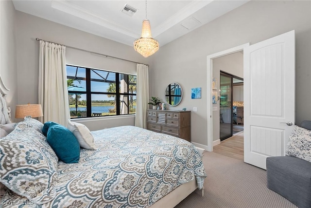 bedroom featuring light colored carpet, a water view, visible vents, baseboards, and a raised ceiling