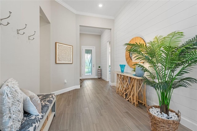 interior space with baseboards, ornamental molding, wood finished floors, and recessed lighting