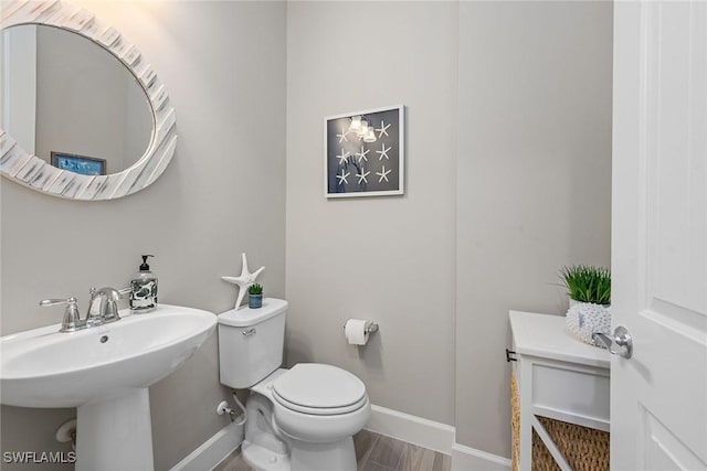 bathroom featuring toilet and baseboards