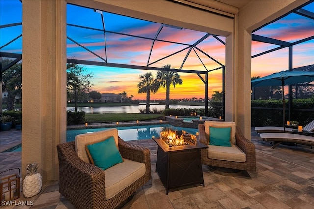 view of patio featuring a lanai, a water view, and a pool with connected hot tub