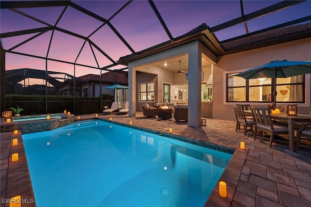 pool at dusk featuring a patio, outdoor dining area, a lanai, an outdoor hangout area, and a pool with connected hot tub