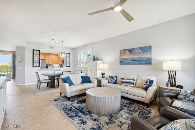 living room with light tile patterned floors, a ceiling fan, and baseboards