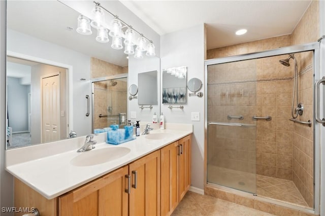 full bath featuring double vanity, tile patterned floors, a sink, and a shower stall