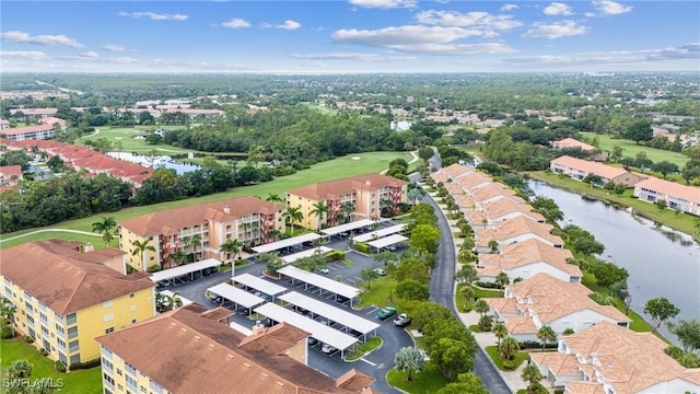 drone / aerial view featuring a water view, view of golf course, and a residential view