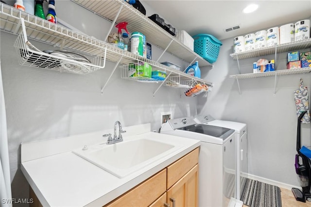 laundry area featuring recessed lighting, visible vents, washing machine and dryer, a sink, and baseboards