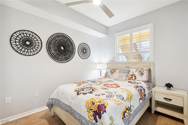 bedroom with ceiling fan, wood finished floors, and baseboards