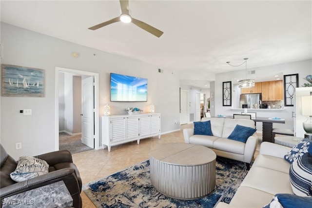 living area featuring light tile patterned floors, visible vents, a ceiling fan, and baseboards