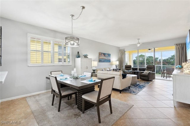 dining room with ceiling fan with notable chandelier, baseboards, and light tile patterned floors