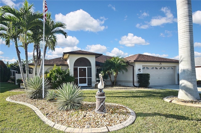 mediterranean / spanish-style house with an attached garage, driveway, a front yard, and stucco siding