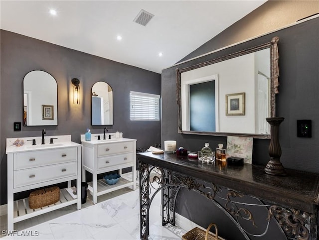 full bathroom featuring visible vents, a sink, marble finish floor, vaulted ceiling, and two vanities