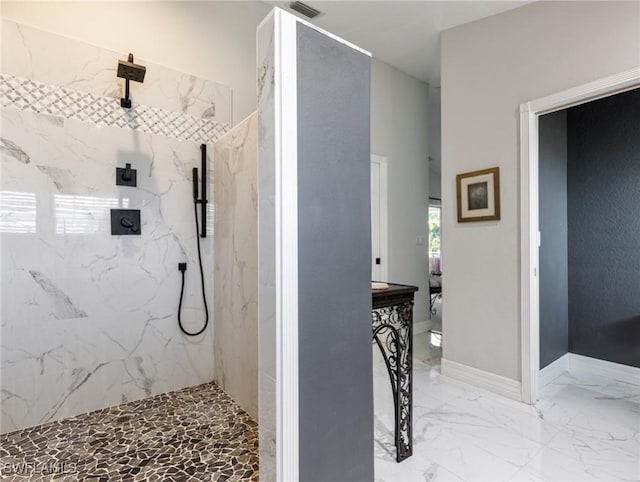 bathroom featuring marble finish floor, a marble finish shower, visible vents, and baseboards