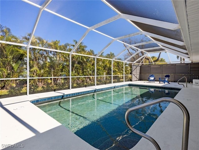 pool featuring glass enclosure and a patio