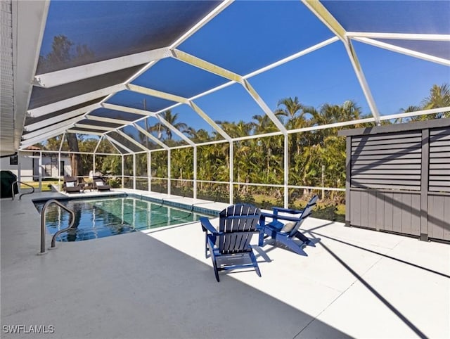 outdoor pool featuring glass enclosure and a patio area