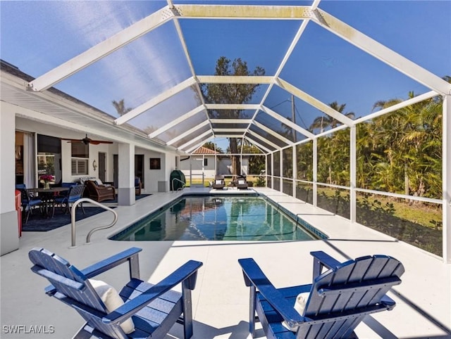 pool featuring a ceiling fan, glass enclosure, and a patio area