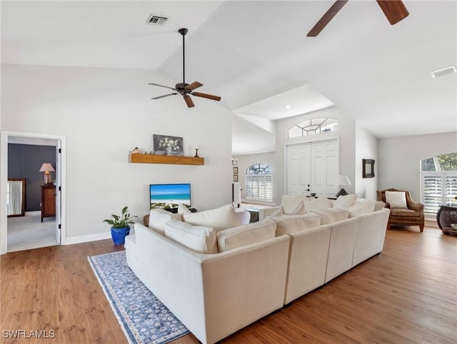 living room featuring ceiling fan, plenty of natural light, wood finished floors, and visible vents