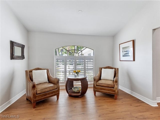 living area featuring baseboards and wood finished floors