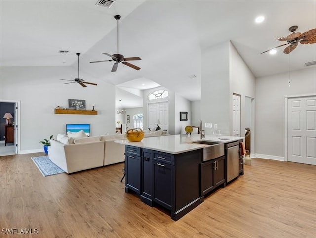 kitchen with open floor plan, light countertops, a sink, and light wood-style flooring