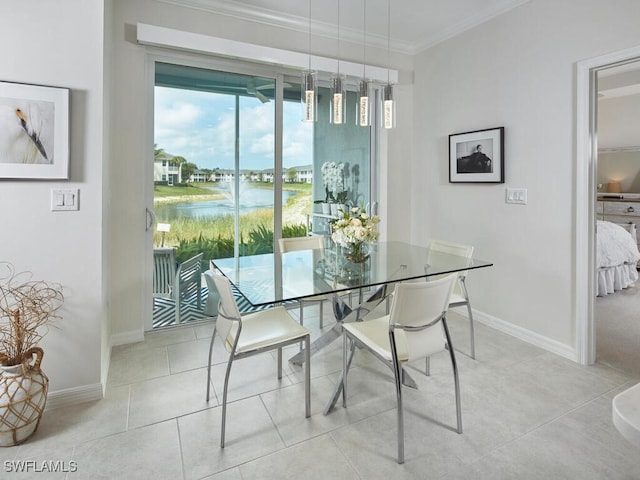 dining room featuring baseboards, ornamental molding, a water view, and tile patterned flooring