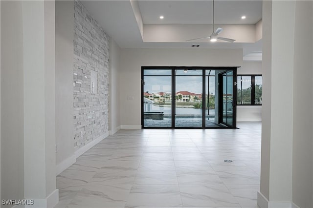 unfurnished room with marble finish floor, visible vents, a towering ceiling, a ceiling fan, and baseboards