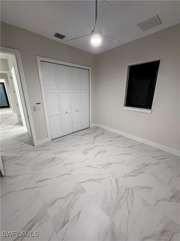 bedroom with marble finish floor, visible vents, and a closet