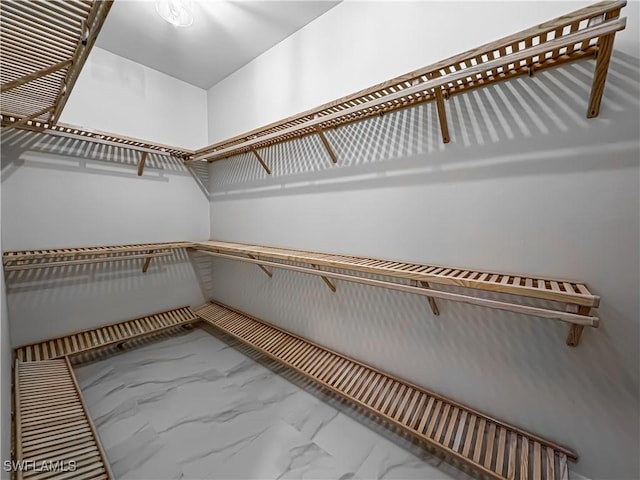 spacious closet featuring marble finish floor