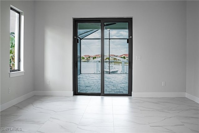 unfurnished room featuring marble finish floor and baseboards