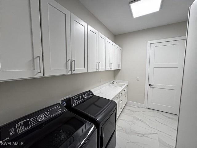 washroom with a sink, baseboards, marble finish floor, cabinet space, and washer and clothes dryer