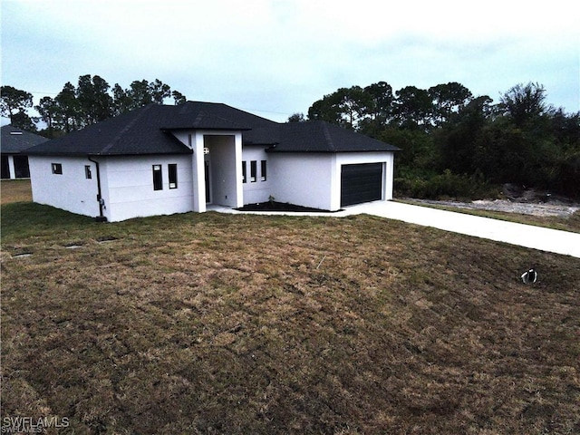 view of front of house with a garage, driveway, and a front lawn