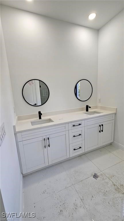 bathroom with double vanity, a sink, and recessed lighting