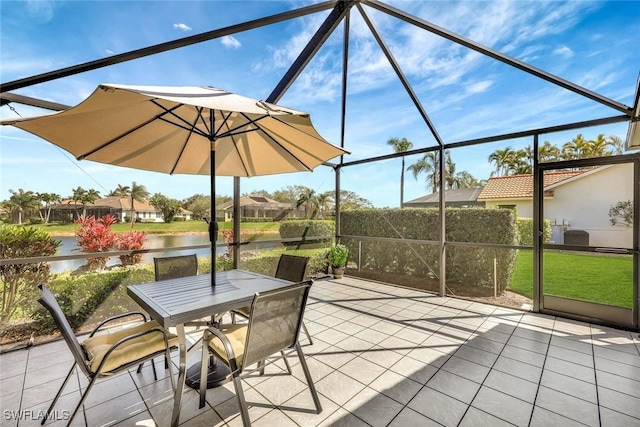 view of patio / terrace with a lanai, a water view, and outdoor dining area