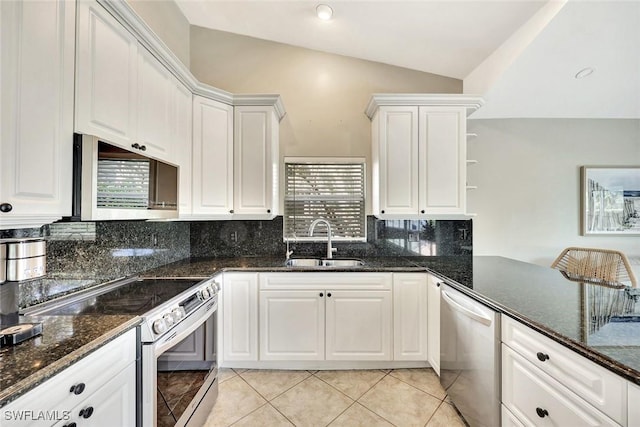 kitchen featuring lofted ceiling, white cabinetry, stainless steel appliances, and a sink