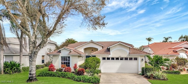 mediterranean / spanish-style house with a garage, a front yard, driveway, and stucco siding