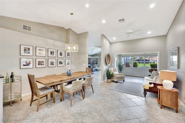 dining space featuring high vaulted ceiling, light tile patterned flooring, visible vents, and ceiling fan with notable chandelier